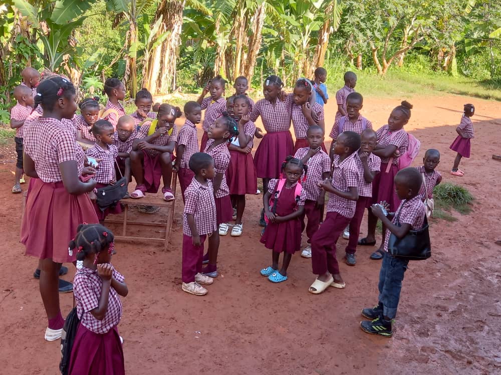 Wide view of children in school uniforms gathered in an open yard