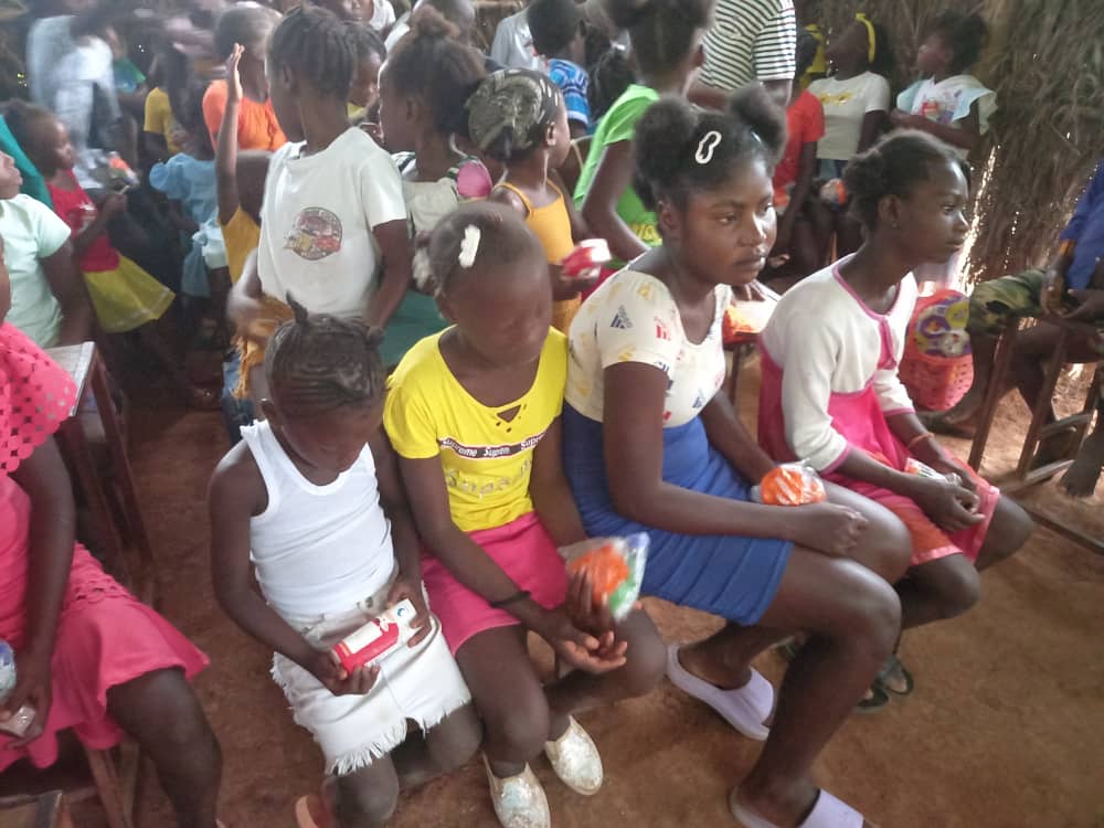 Young children standing together, some eating snacks